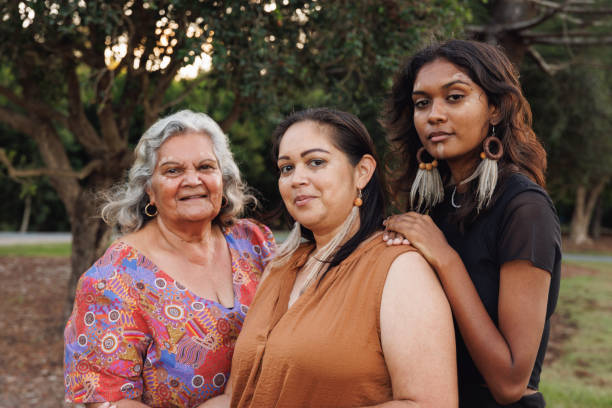 Three Generations Of Aboriginal Australian Women Three Generations Of Aboriginal Australian Women Doing Traditional Ochre Face Painting aborigine woman stock pictures, royalty-free photos & images