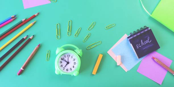 istock Alarm clock, Art materials and stationery on a green background, top view 1479597399