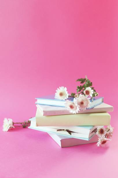 istock A stack of books with bookmarks from fresh chrysanthemum flowers, on a pink background 1479597420