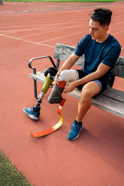 istock man athlete sitting in a bench and putting on his leg prosthesis 1479601961