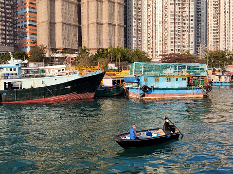 Local people on a small fishing boat in Aberdeen, a town on southwest Hong Kong Island in Hong Kong. Aberdeen is famous is famous for its floating village in the Aberdeen Harbour.
