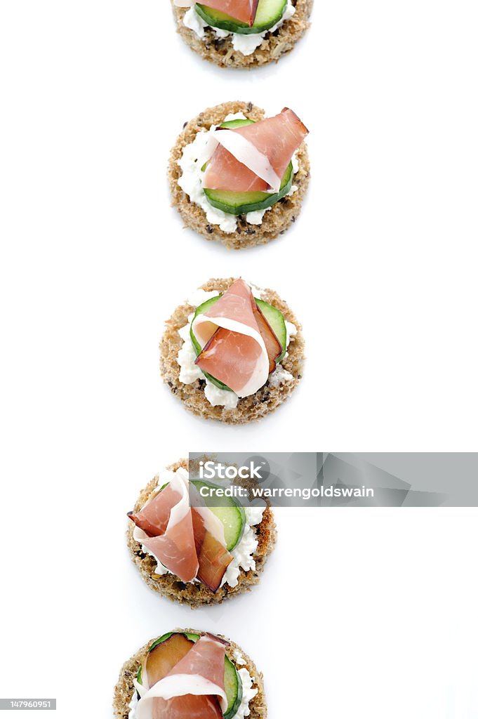 Platter of ham appetisers Multiple smoked meat starters on a white platter Canape Stock Photo