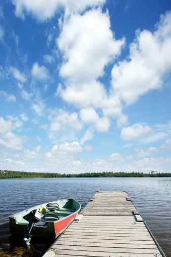 fishing boat on wilderness lake with bright sky, vertical frame (XXXL)
