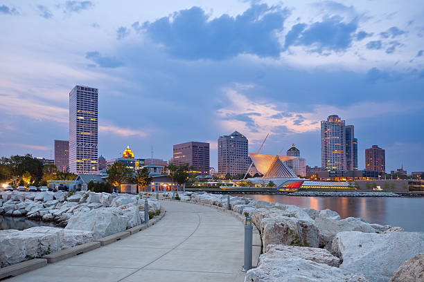 City of Milwaukee skyline. Image of Milwaukee skyline at twilight with city reflection in lake Michigan and harbor pier. milwaukee wisconsin photos stock pictures, royalty-free photos & images