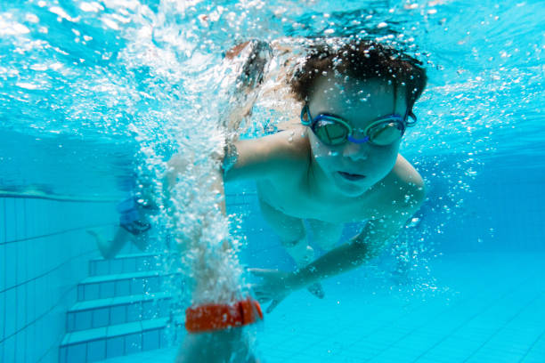istock Cute boy is swimming underwater in the pool 1479627238