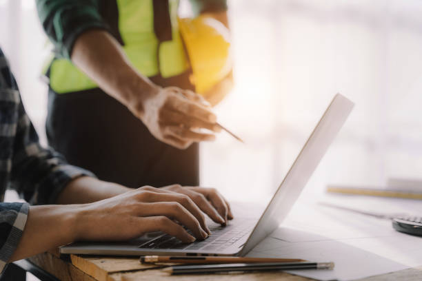 istock business man hand working and laptop with on on architectural project at construction site at desk in office. 1479634737