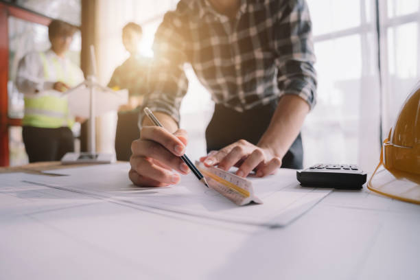 istock Person's engineer Hand Drawing Plan On Blue Print with architect equipment, Architects discussing at the table, team work and work flow construction concept. 1479634784