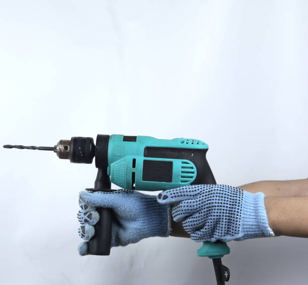 istock Gloved hand holding electric drill isolated on white background 1479637830