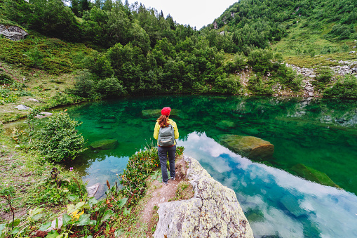 Young adult woman at mountain lake looking at view