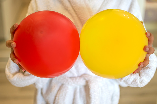 Little girl enjoyment with red and yellow ballons