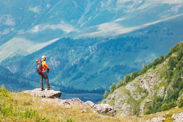 istock Young adult man standing at the mountain range and looking at view 1479641200