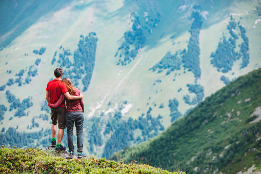 Young adult couple standing at the edge in mountain