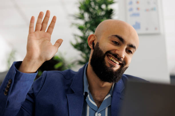 istock Smiling entrepreneur attending remote conference call and greeting employees 1479646956