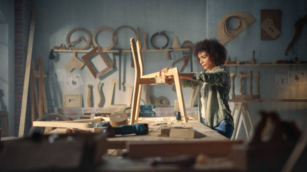 designer de meubles artisan marquant les dimensions sur un plan et commençant à assembler une chaise en bois. charpentier noir multiethnique travaillant dans un studio - menuisier photos et images de collection
