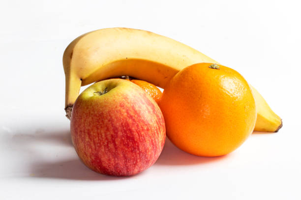 Apple, orange, tangerine, banana on white background in close-up