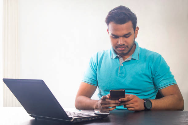 istock smiling young man sitting by laptop reading text message 1479665865