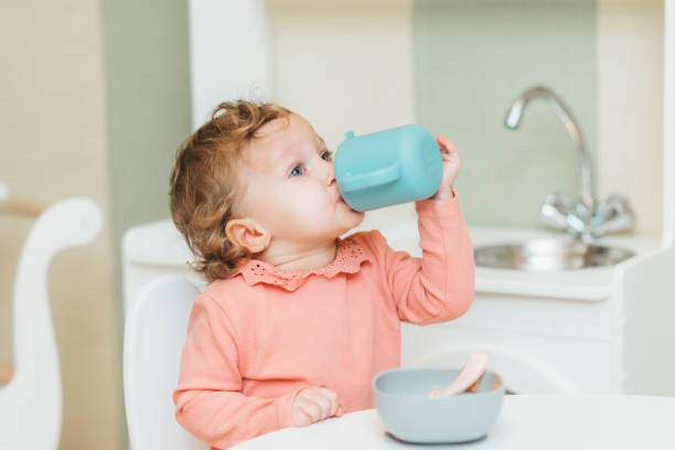 istock Little girl drinking water from a plastic cup 1479674598