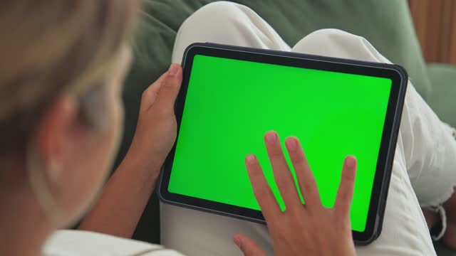 Woman tap tablet green screen. Horizontal chroma key display. Person click pad.