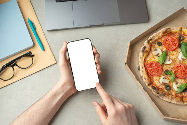 istock A man works and eats pizza, top view, hands on the desktop.Pizza delivery. 1479678143