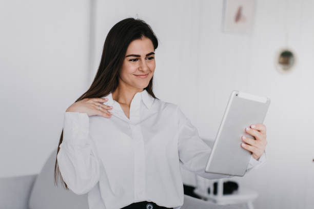 istock Attractive brunette Hispanic psychologist talks with client by tablet makes video call home over blurry kitchen. Successful businesswoman disputes with partner via internet. Lawyer remote consulting. 1479679008