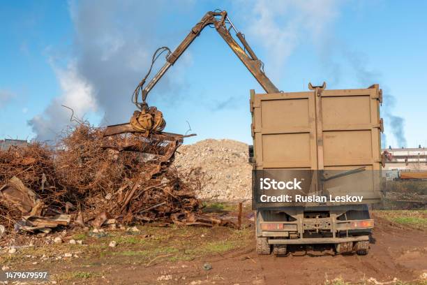 A Grapple Truck Loads Scrap Industrial Metal For Recycling Manipulator With  A Hydraulic Magnetic Crab Against The Sky Crane Garbage Truck Loading Of  Industrial Waste Stock Photo - Download Image Now - iStock