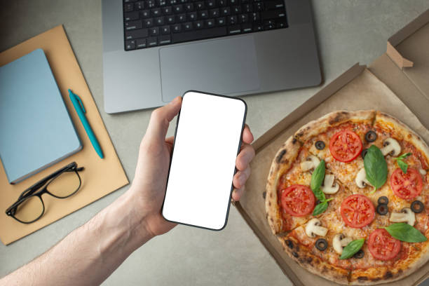 istock A man works and eats pizza, top view, hands on the desktop.Pizza delivery. 1479681483
