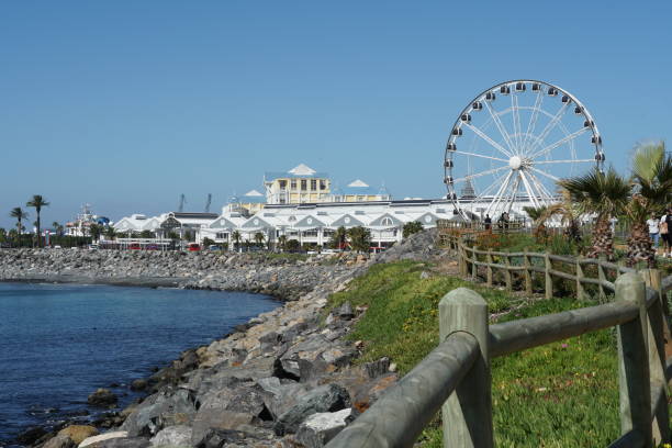 istock Vibrant Waterfront precinct in Cape Town behind blue romantic bay with stone beach. 1479684170