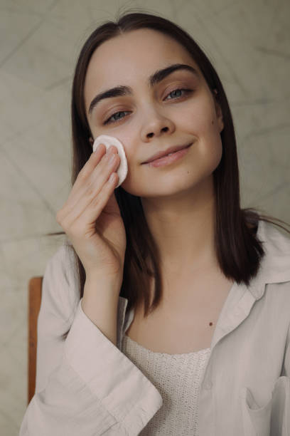 istock Woman removing make-up with cotton pad during skin care routine 1479685912