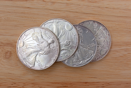 Several large American silver coins on a wood table
