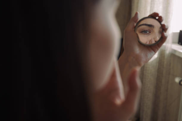 istock Female with mirror ding beauty treatment in morning 1479686002