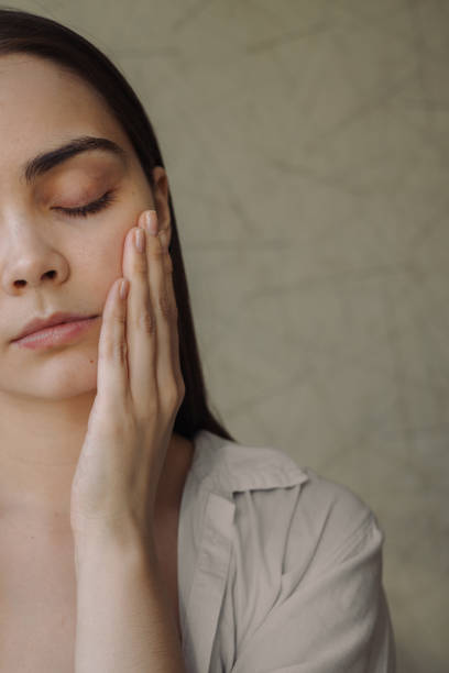 istock Young woman applying moisturizer during skin care treatment 1479686041