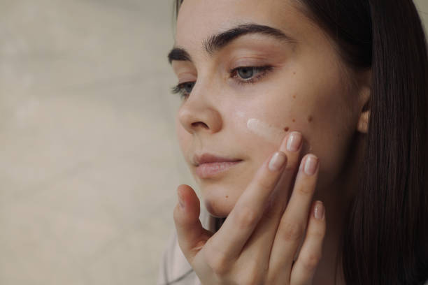istock Woman applying moisturizer on face during beauty routine 1479686073