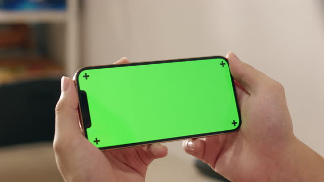 Close up Hand holding smart phone using green screen