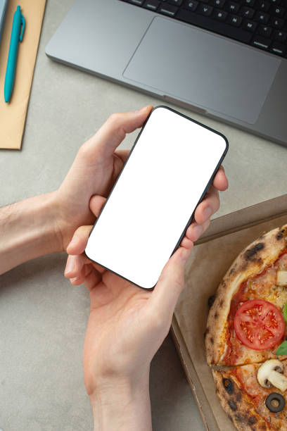 istock A man works and eats pizza, top view, hands on the desktop.Pizza delivery. 1479686830