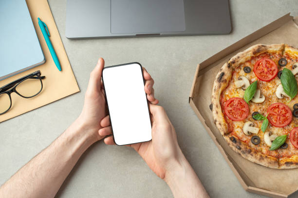 istock A man works and eats pizza, top view, hands on the desktop.Pizza delivery. 1479687002