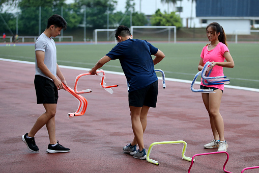 Asian young adults are arranging low bars for routine athletic training in stadium