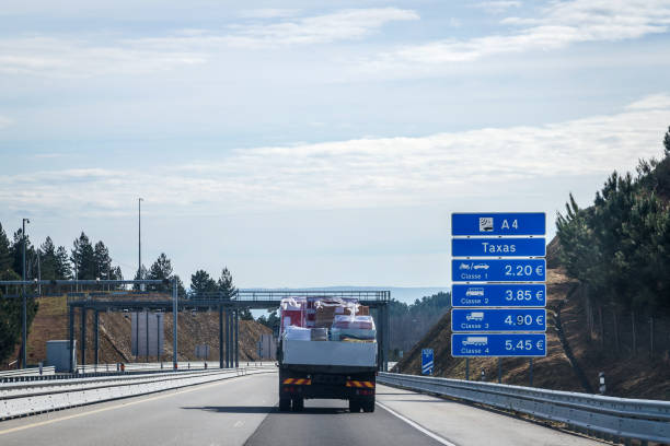 istock Blue information board for fees payable on the A4 motorway for different vehicle categories. Goods transport van passing on the highway. 1479688645