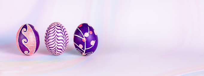 Easter composition made of beautiful contemporary Easter eggs with painted in pink, lilac, purple and violet colors with unique design