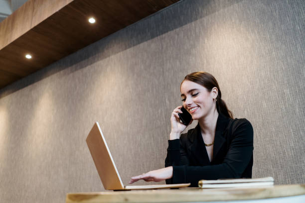 istock Young businesswoman talking on phone and using computer 1479691085