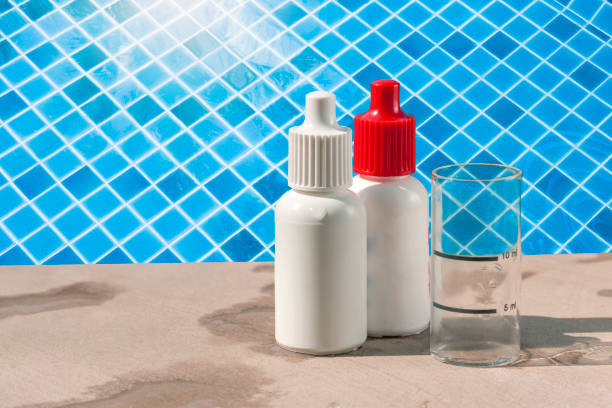 istock Plastic bottle of pH and Chlorine solution with glass beaker over swimming pool background 1479691147