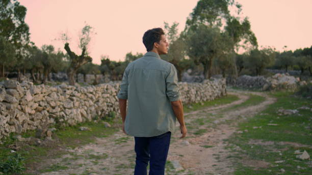 istock Serious man examining garden closeup. Guy walking olive trees plantation alone 1479691818