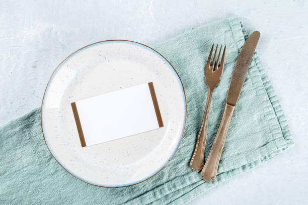 istock Dinner invitation. A card on a plate, with a fork and a knife 1479692007