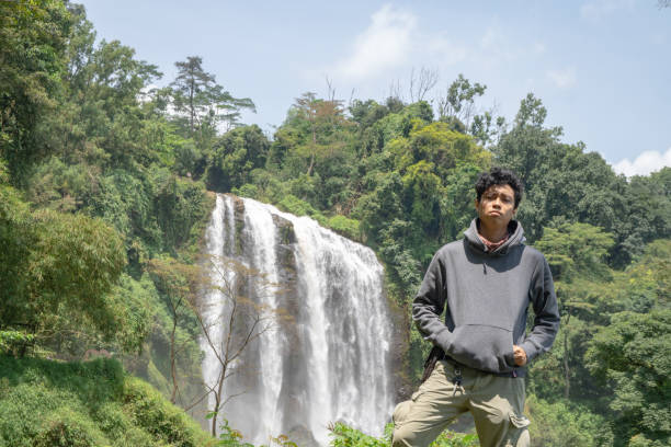 istock Man pose in front of the high water fall on the tropical forest. 1479692577