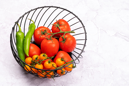 Fresh garden vegetables in basket. Tomatoes and pepper. Italian cuisine. With copy space