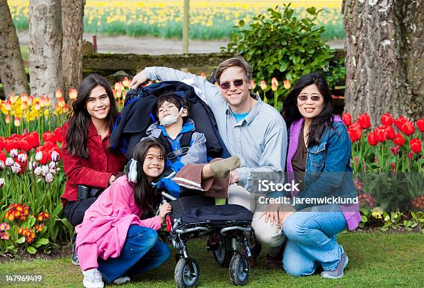 Photo libre de droit de Famille Avec Garçon À Mobilité Réduite Dans Les Jardins De Tulipes banque d'images et plus d'images libres de droit de Famille