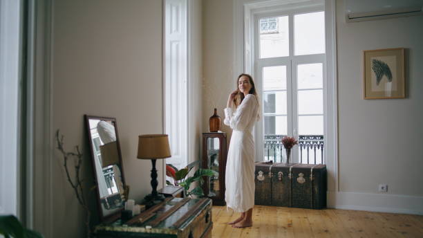 istock Dreaming model watching window cozy interior. Tender woman touching hair posing 1479694311