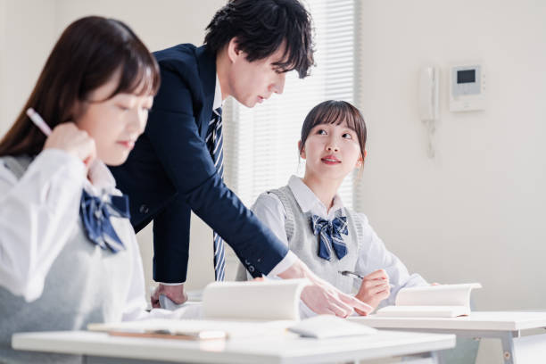 istock High school student asking a question to her teacher in the classroom 1479697307