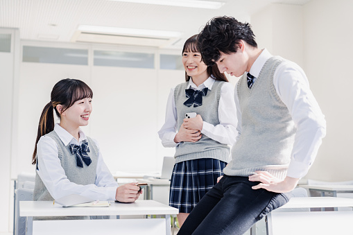High school students chatting with classmates in the classroom