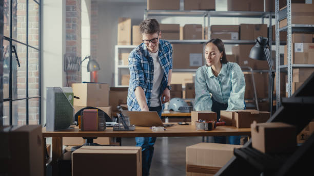 istock Positive Young Male and Female Working in Warehouse. Talking, Using Laptop Computer, Checking Retail Stock, Preparing Shipment. Successful Small Business Owners 1479703706