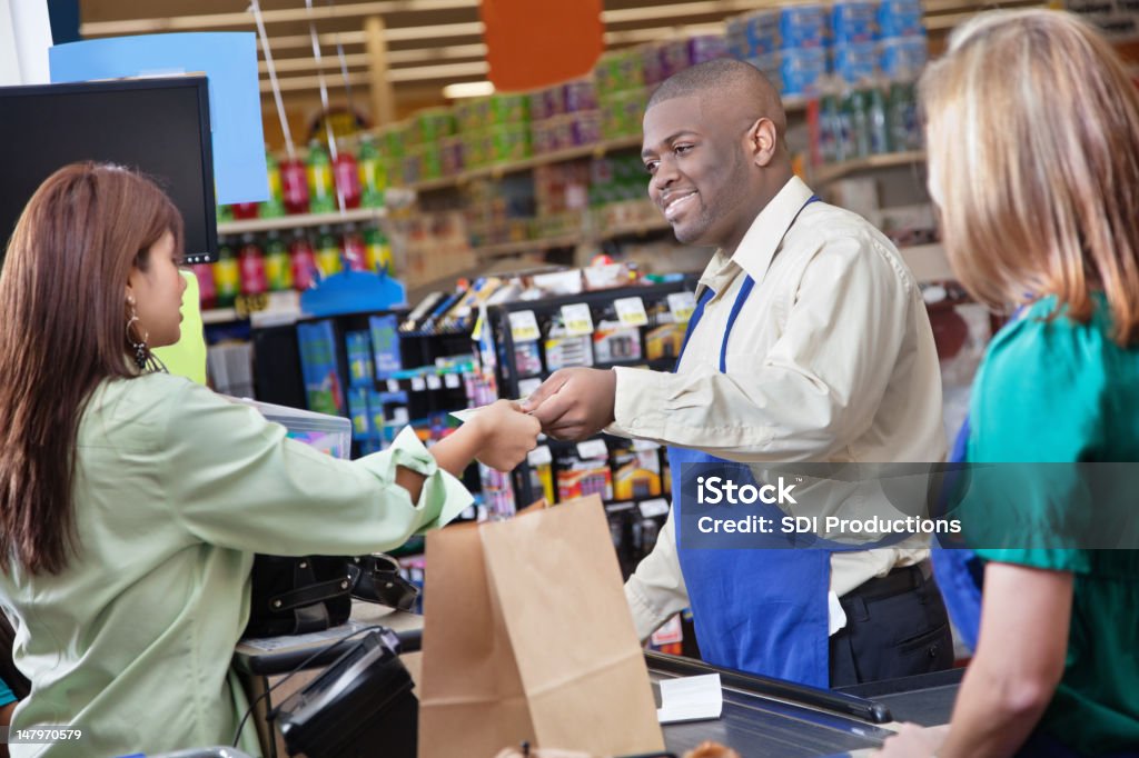 Freundliche Lebensmittelgeschäft clerk gibt zum Kunden - Lizenzfrei Geldschein Stock-Foto